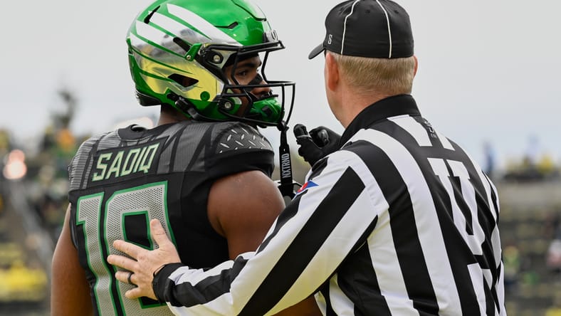 Kenyon Sadiq speaks with an official before a game at Autzen Stadium. Vikings Round 1 pick