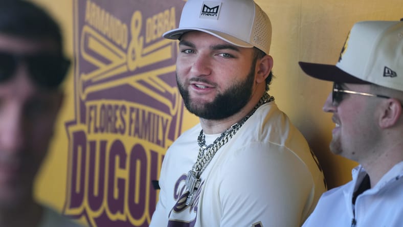 Cam Skattebo playing in a celebrity softball game at Phoenix Municipal Stadium. Cris Carter Cam Skattebo.