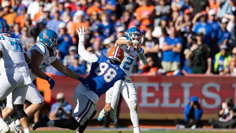 Jaxson Dart throws a pass over Florida defensive lineman Caleb Banks during a game in Gainesville. Vikings rookie minicamp