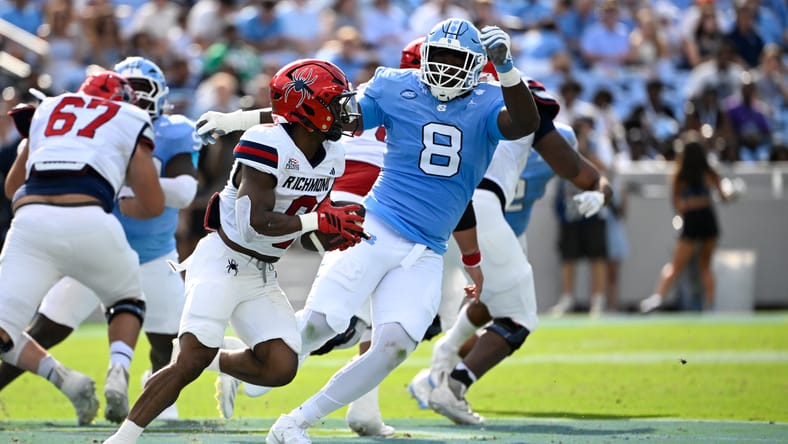 Smith Vilbert defends Richmond running back Andrew King during a game at Kenan Stadium.