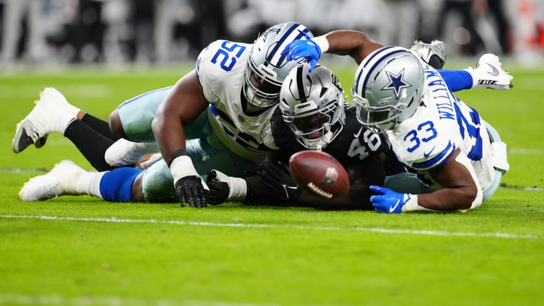 Jamin Davis fights for a loose ball with Cowboys players during a game at Allegiant Stadium. Jamin Davis