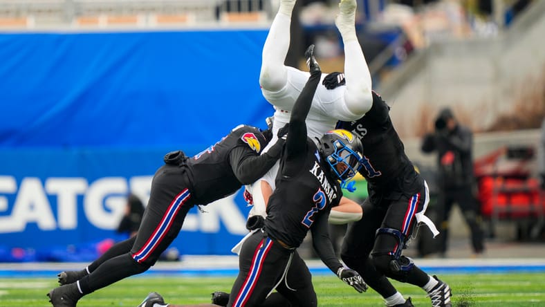 Bangally Kamara helps tackle Utah tight end Dallen Bentley during a game between Kansas and Utah.
