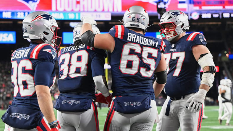 Garrett Bradbury celebrates with Patriots teammates after a touchdown against the Dolphins at Gillette Stadium.