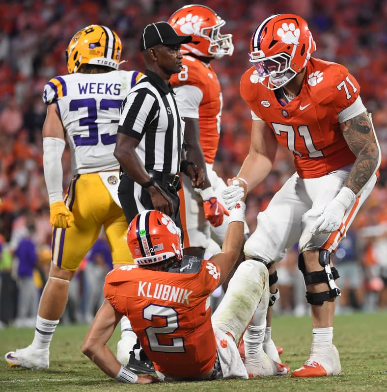 Clemson Tigers offensive lineman Tristan Leigh (71) helps up Clemson Tigers quarterback Cade Klubnik (2) Saturday, Aug. 30, 2025