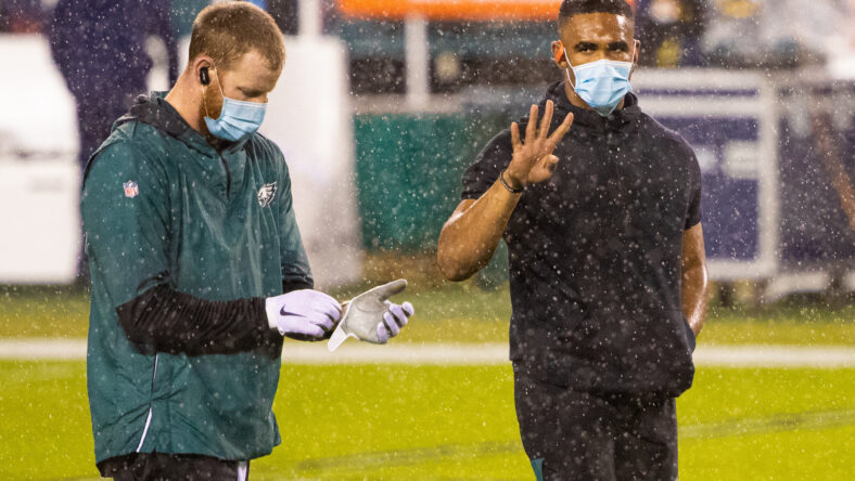 Carson Wentz and Jalen Hurts stand on the sideline before the Eagles-Seahawks game in Philadelphia.